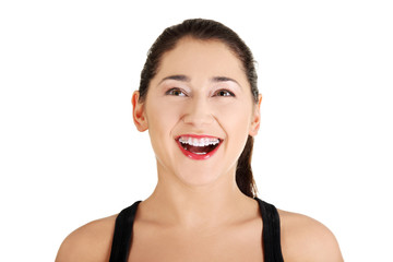 Portrait of a happy amazed young woman looking up.