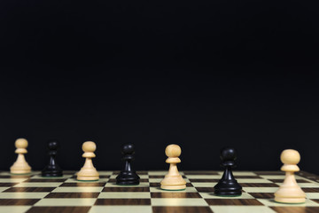 Playing pawns diagonally on a chessboard, black background