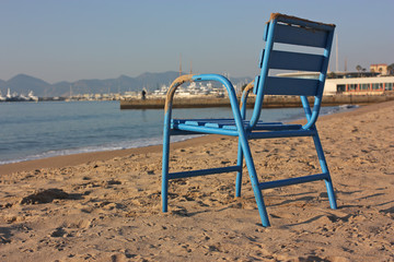 une chaise bleue sur la plage de sable à cannes