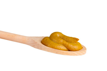 Mustard in a wooden spoon isolated on white
