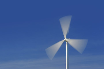 Wind turbine in movement against blue sky