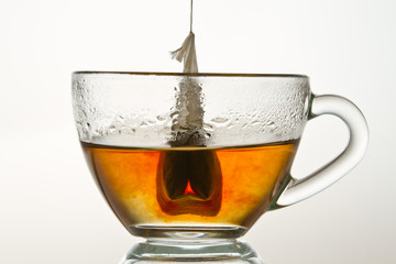 Teabag in a cup filled with hot water isolated on white backgrou