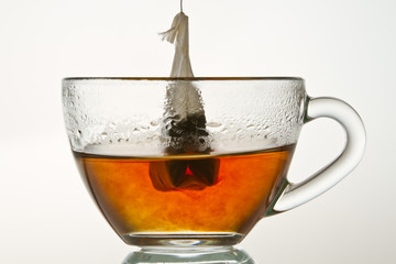 Brewing up hot tea with teabag isolated on white background