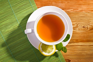 Hot tea and lemon on bamboo mat