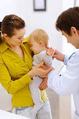 Fototapeta premium Scared baby on examination don't want to be checked by doctor