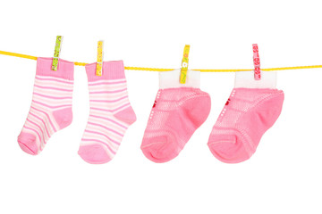 pink baby socks on rope isolated on white