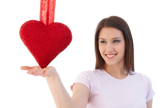 Woman in love balancing with red heart