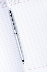 silver pen on notebook vertical