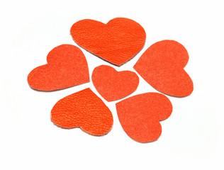 Red leather and paper hearts on white background.