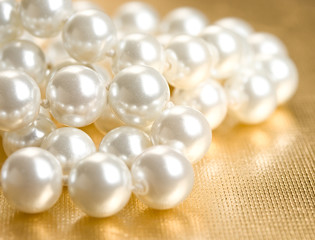 String of pearls on golden surface