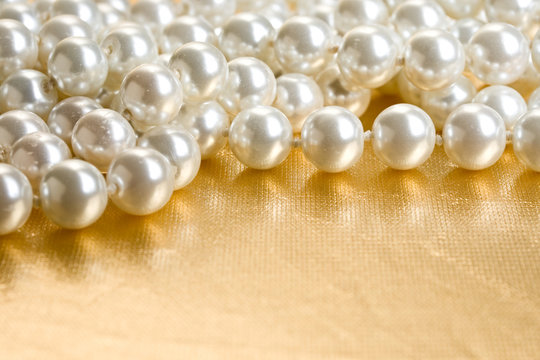 String of pearls on golden surface