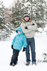 Fototapeta na wymiar Dad and son walking in a winter park