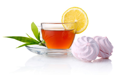 Cup of black tea with lemon, green leaves and marshmallow isolat