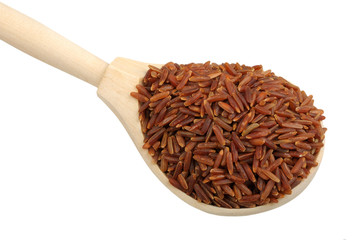 red rice on wooden spoon