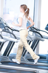 Fototapeta na wymiar Young woman at the gym exercising. Running