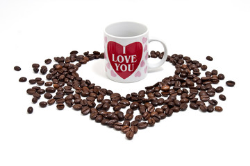 A cup of coffee with many coffee beans in shape of heart