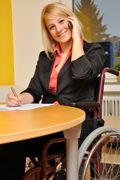 Frau im Rollstuhl telefoniert