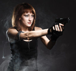 Sexy woman holding gun with smoke