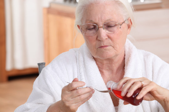 Senior Woman Taking Cough Syrup