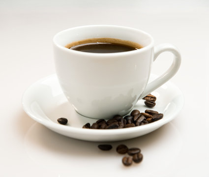 Cup of coffee and beans over white background