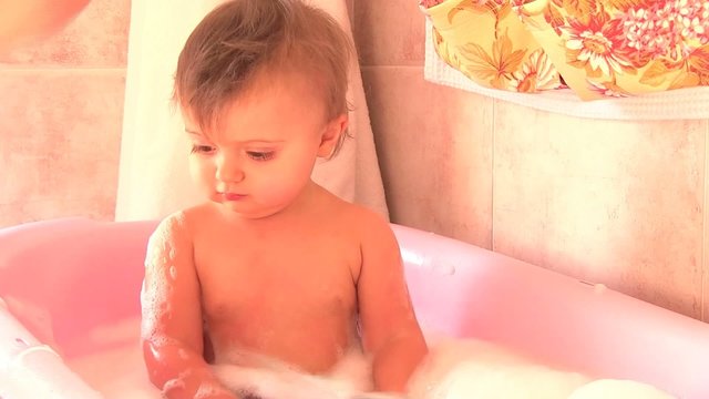 bambina gioca e si diverte mentre fa il bagno