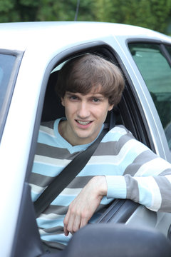 Young man leaning out of car window