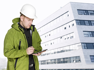 Bau-Ingenieur mit PC-Tablet vor Neubau-Fassade