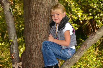 Girl sitting on tree limb