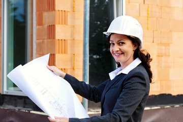 Architekt mit Bauplan auf Baustelle