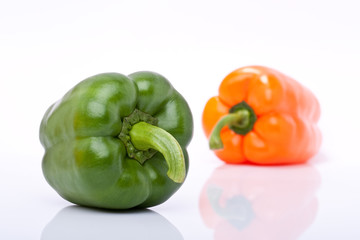 orange und grüne Paprika freigestellt vor weissem Hintergrund