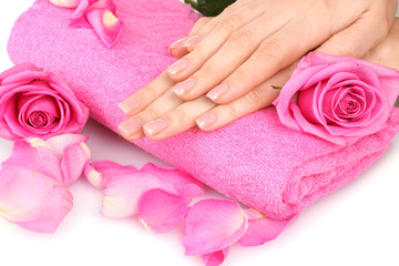 Obraz na płótnie Canvas Pink towel with roses and hands on white background