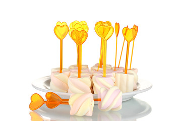 Marshmallows with skewers on plate isolated on white