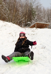 Fototapeta na wymiar Young girl sledding