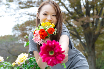 Fototapeta premium Beautiful young woman in flower garden