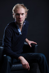 Pretty young man posing on black background