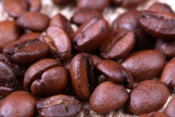 Naklejka premium Roasted coffee beans on linen sackcloth