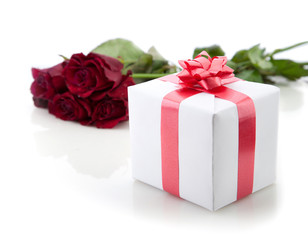 A bouquet of roses and a romantic gift on white background.