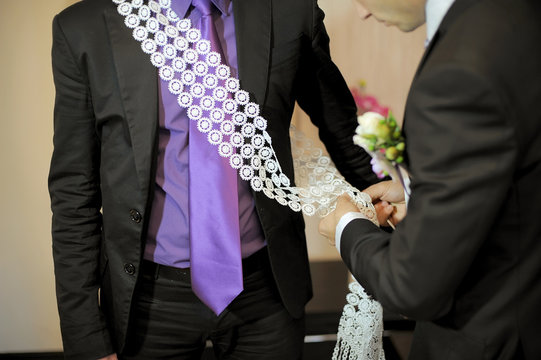 Pinning a decorated lace ribbon at wedding party