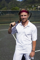 Tennis player smiles with his racquet