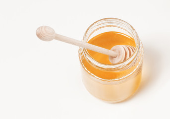 Miele in barattolo e cucchiaio