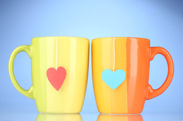 Two cups and tea bags with red and blue heart-shaped label