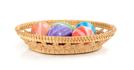 Fototapeta na wymiar Easter colored eggs in the basket on white background