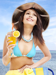 Girl in bikini drinking cocktail.