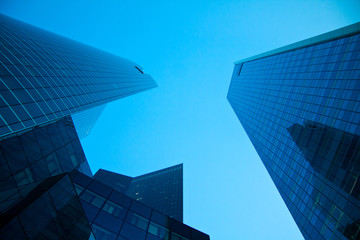 Obraz na płótnie Canvas Skyscrapers and blue sky view from below