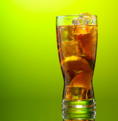 Iced tea with lemon and lime on green background