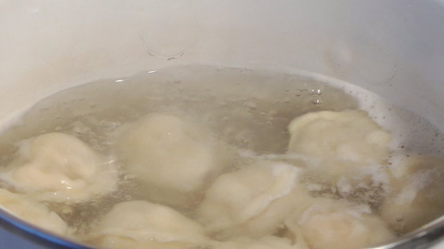 Meat dumplings cook in a pan.