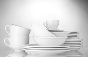 empty bowls, plates and cups on gray background