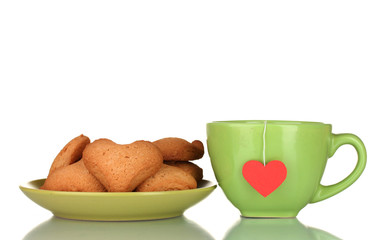 Green cup with tea bag and heart-shaped cookies