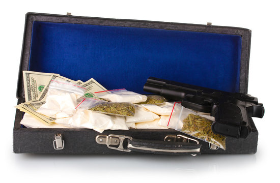 Cocaine and marijuana with gun in a suitcase isolated on white