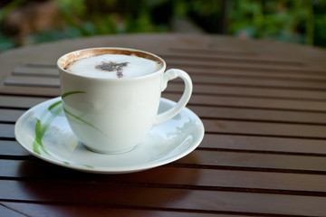 A cup of cappuccino coffee on wood table